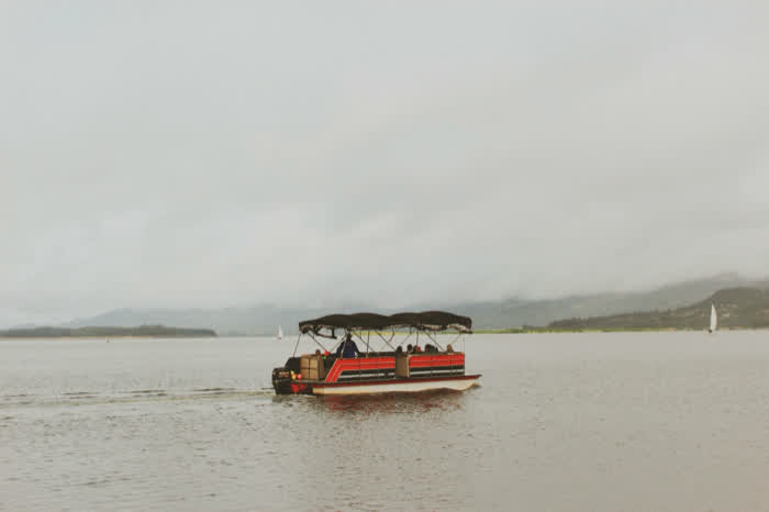 A pontoon boat crossing a misty lake