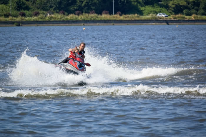 A rider throwing spray on a jet ski