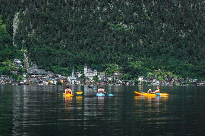 Kayaks out on a lake below a village